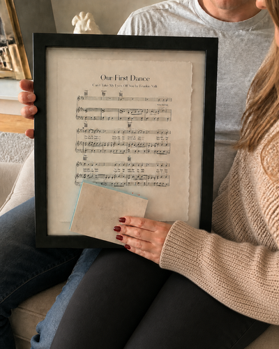 Customer holding a personalised sheet music float mount anniversary print